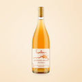 orange natural wine bottle on a soft cotton-candy gradient