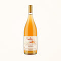 orange natural wine bottle on a soft cotton-candy gradient