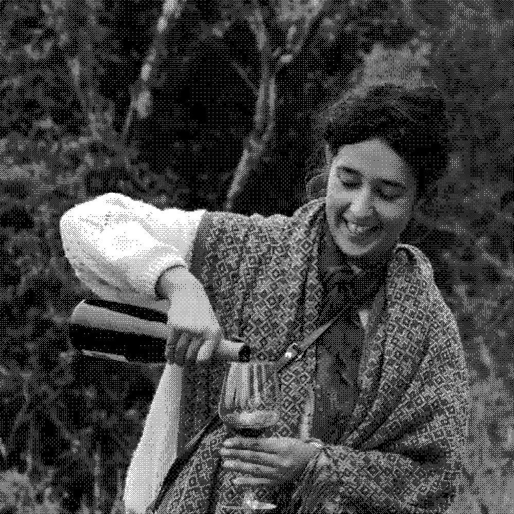 Laura Lees and Arthur Joly of Les Abrigans, natural wine producer in the Corbieres, Languedoc, France, with Laura pouring a glass of red wine in the vineyard