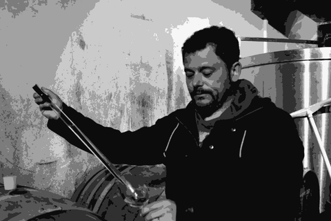 Adrien de Mello of Domaine de la Petite Soeur tasting wine from a barrel in his cellar