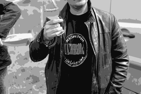 Lambert Spielmann of Domaine in Black holding a glass of his wine in the vineyard