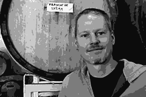 Winemaker Mike Hinds of Franchere Wine Company standing in front of a barrel in his Oregon cellar