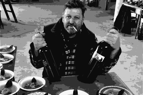 Franco Terpin holding two bottles of his wine in his cellar in San Floriano del Collio, Friuli