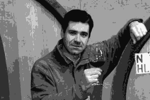 Guido Porro with a glass of Barolo among the large oak botti in his Serralunga cellar