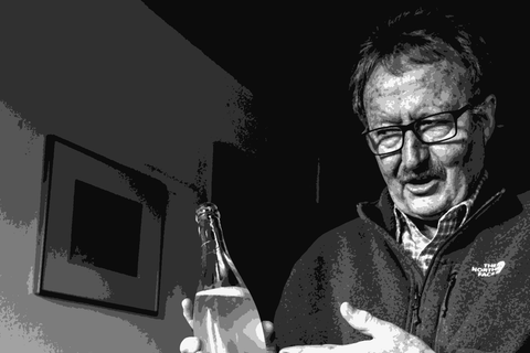 Helmut Dolde holding a bottle of his sparkling wine at his home in Linsenhofen, Swabia