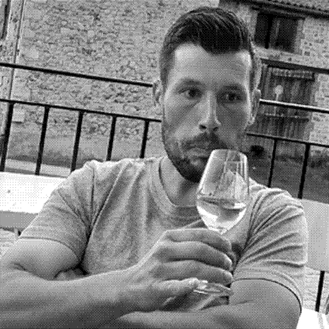 Henri Chauvet, natural wine producer, at his domaine in Boudes, Auvergne, France, holding a glass of wine