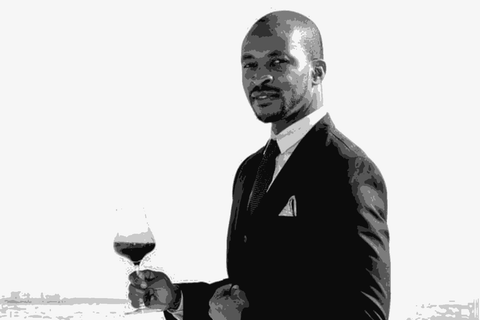 Tinashe Nyamudoka of Kumusha Wines holding a glass of wine