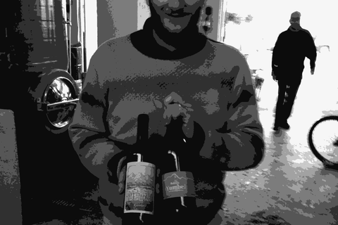 Louis-Antoine Luyt holding bottles of his wine in the cellar