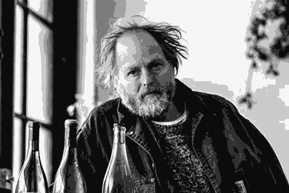 Anton van Klopper of Lucy Margaux holding a bottle of his wine