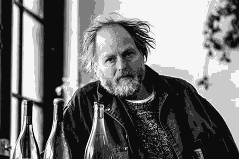 Anton van Klopper of Lucy Margaux holding a bottle of his wine