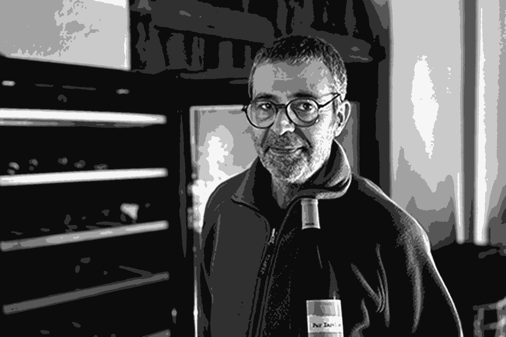 Ramon Parera, co-founder of Celler Pardas, holding a bottle of wine in the estate cellar