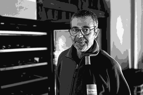 Ramon Parera, co-founder of Celler Pardas, holding a bottle of wine in the estate cellar