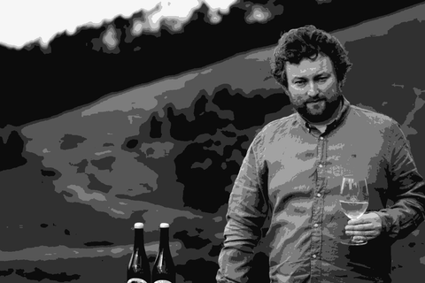 Patrick Sullivan, winemaker and viticulturist, standing in the green Gippsland hills holding a glass of white wine