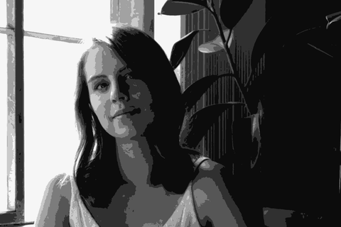 Rachel Silkowski DeAscentiis seated near a window holding a glass of red wine