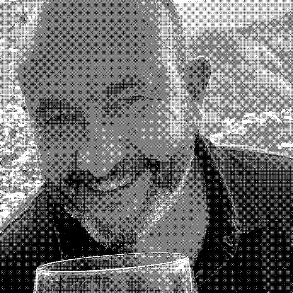 Andrea Scovero, natural wine producer, smiling with a glass of red wine in his vineyard in Piedmont, Italy