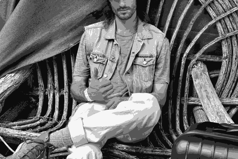 Brent Mayeaux of Stagiaire Wine seated outdoors, casual portrait with cap and denim vest