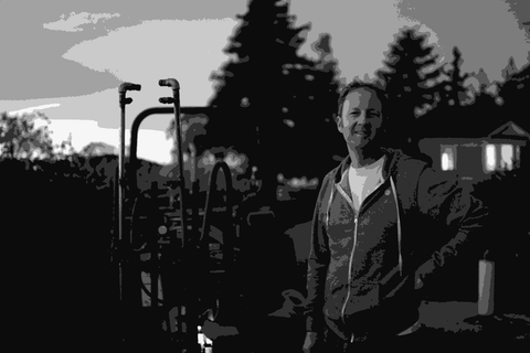 Steve Matthiasson standing by farm equipment at dusk at his Napa Valley property