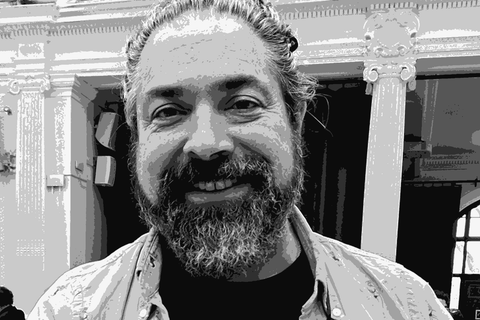 Roberto Echeverría, winemaker at Viña Echeverría, smiling at a wine fair wearing a No Es Pituko t-shirt and holding a bottle