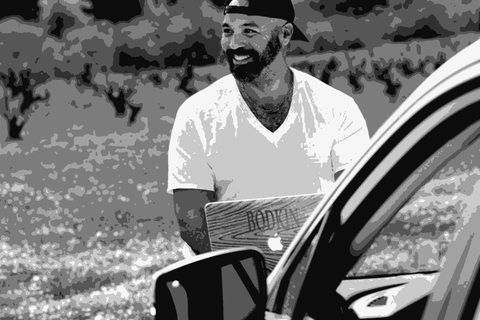 Chris Christensen, winemaker behind Where's Linus?, smiling outdoors in a vineyard wearing a backwards cap and white t-shirt