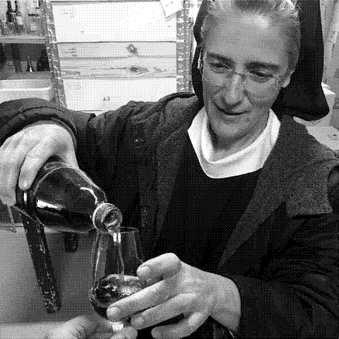 Monastero Suore Cistercensi, natural wine producer, a Cistercian sister pouring wine in the cellar at the monastery in Vitorchiano, Lazio, Italy