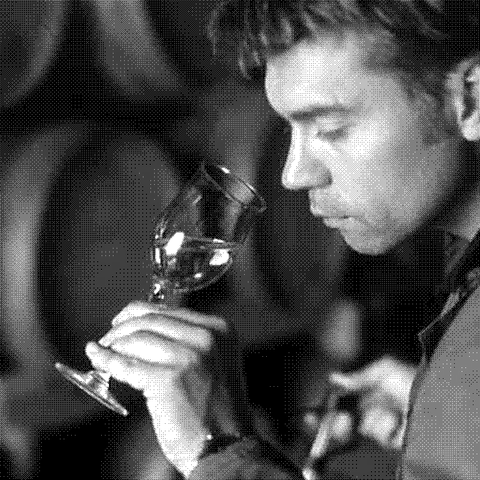 Giovanni Scaglione, natural wine producer of Forteto della Luja, nosing a glass of Moscato in his barrel cellar in Loazzolo, Piedmont, Italy