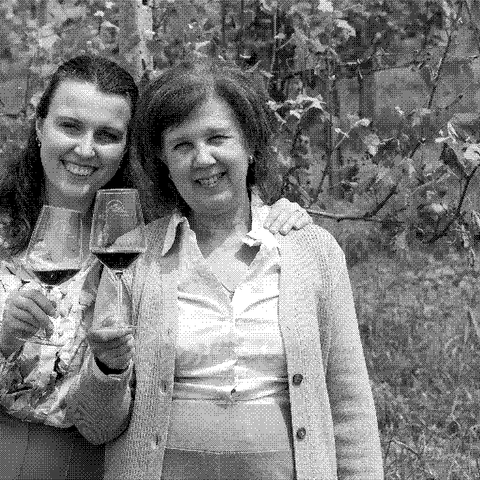 Tenuta la Pergola, natural wine producer, two of the family winemakers holding glasses of wine in their vineyard in Cisterna d'Asti, Piedmont, Italy